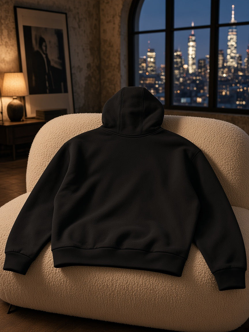 Marcel Afters Heavyweight Fleece Boxy Hoodie in Black, laid flat, living room