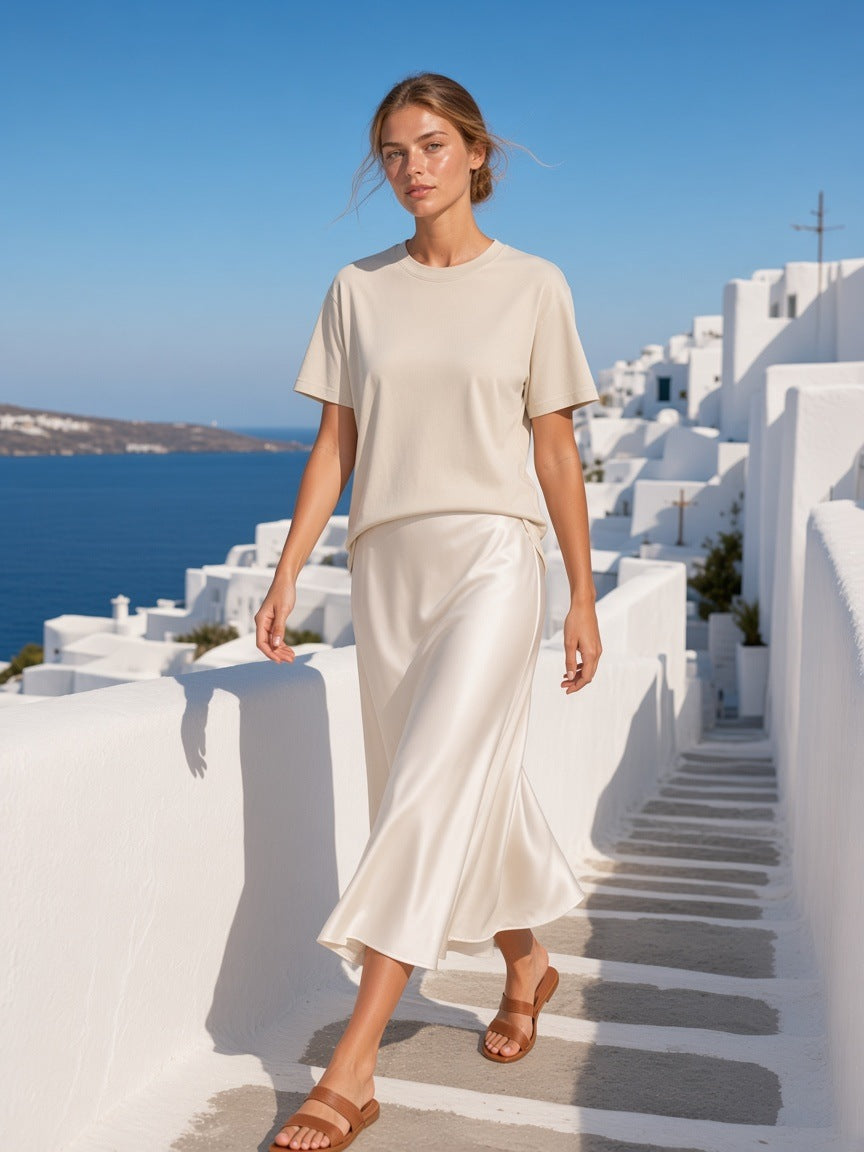 Marcel Afters Loose Drop Shoulder T-Shirt in Khaki, worn by a woman, white buildings