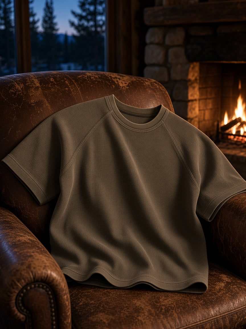 Marcel Afters Mineral Wash Boxy Waffle T-Shirt in Army Green, laid flat, leather armchair
