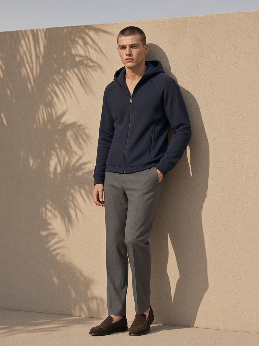 Marcel Afters Paneled Full Zip Hoodie in Navy Blue, worn by a man, leaning on a sandy wall in a navy zip hoodie