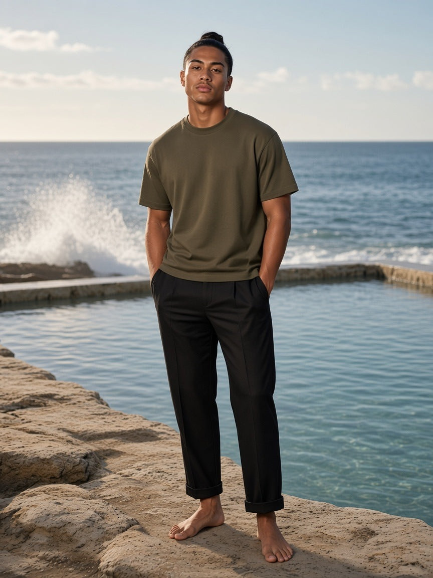 Marcel Afters Sun Fade Distressed Boxy T-Shirt in Army Green, worn by a man, by the sea