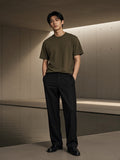 Marcel Afters Sun Fade Distressed Boxy T-Shirt in Army Green, worn by a man, concrete room