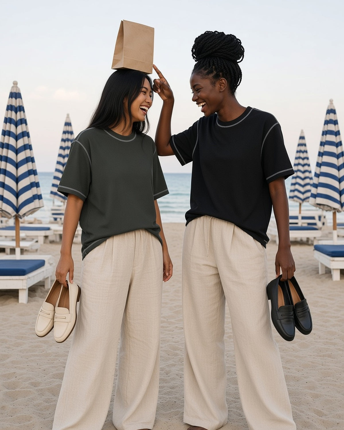 Two women in the Sunfade Waffle Boxy T-Shirt in Gray Green and Black, forehead to forehead at a Riviera beach club