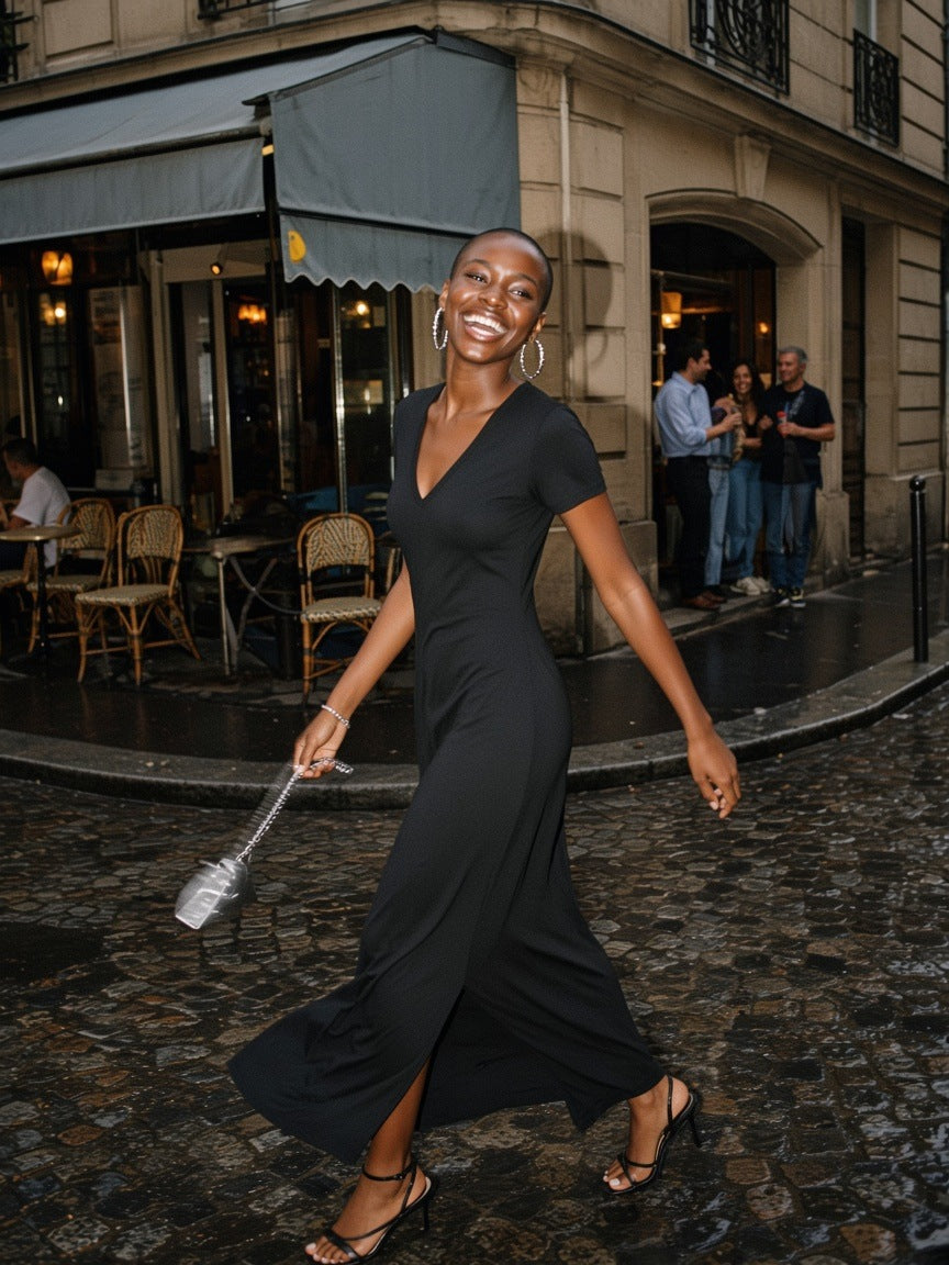 Woman in the Women's V-Neck Short Sleeve Maxi Dress in Black, twirling out of a Marais café at closing time