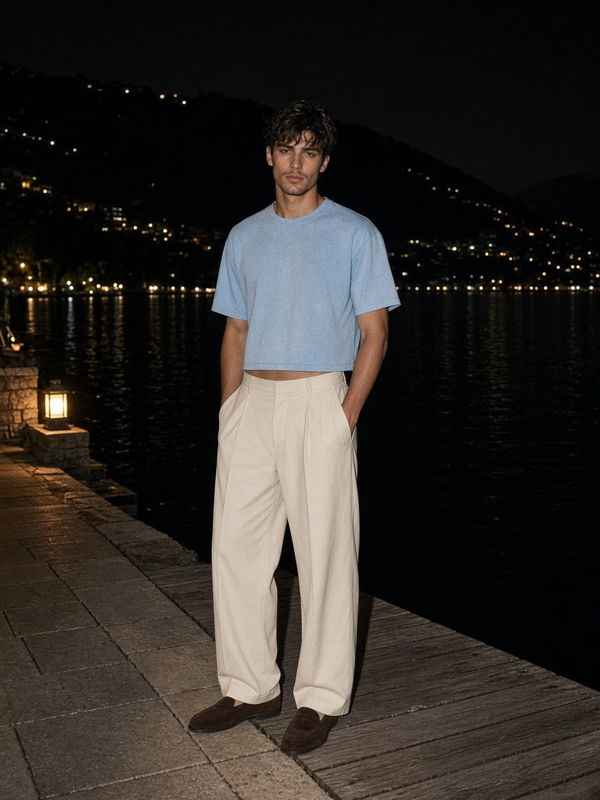 Marcel Afters Vintage Wash Sunfade Boxy T-Shirt in Sky Blue, worn by a man, on a dock at night