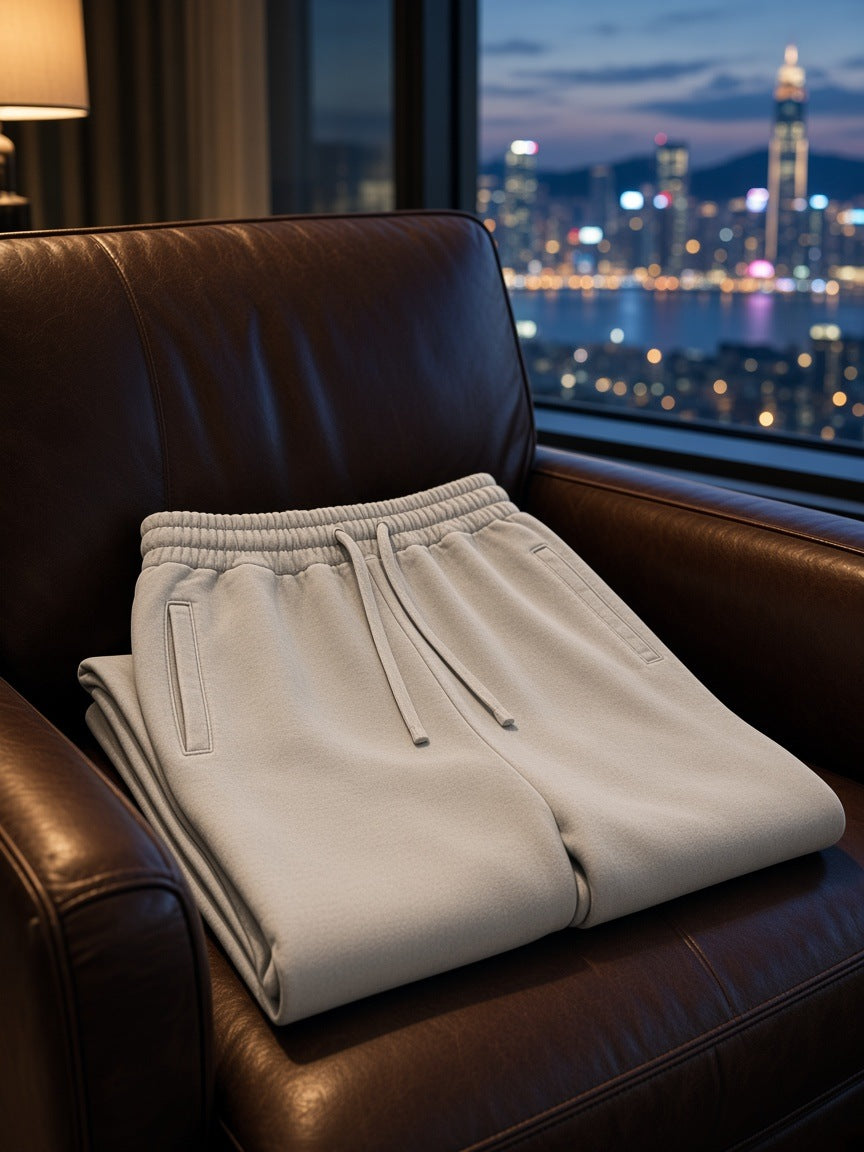 Marcel Afters Vintage Wash Sweatpants in Light Gray, laid flat, leather armchair