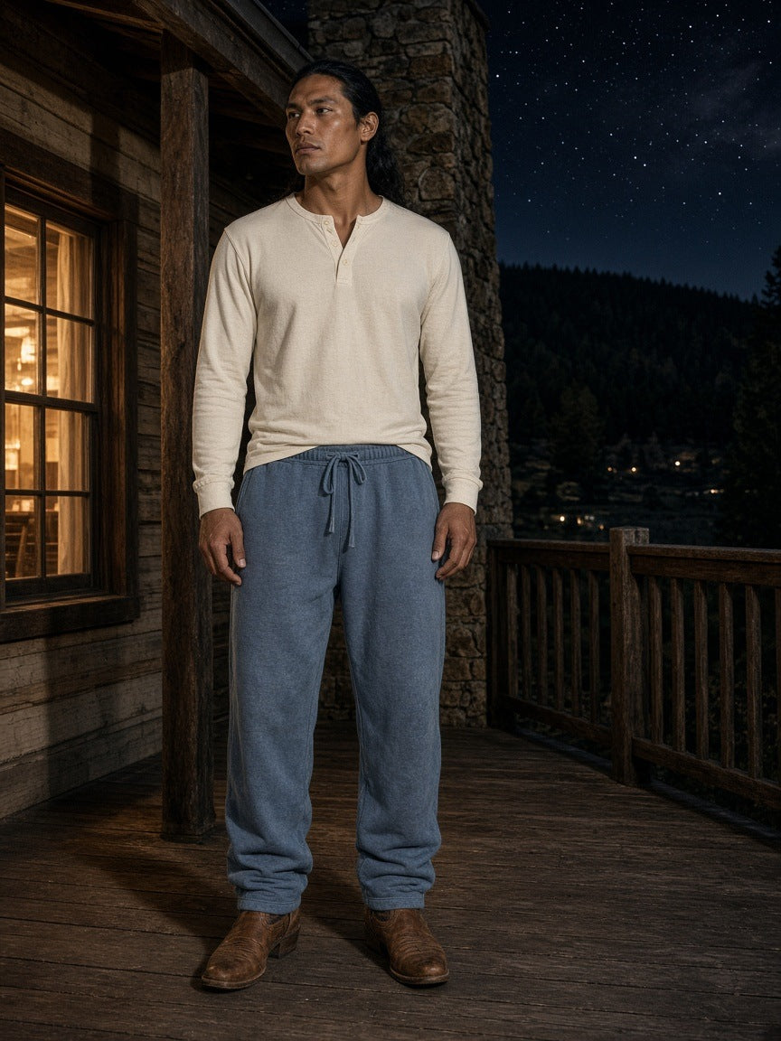 Marcel Afters Vintage Wash Sweatpants in Blue, worn by a man, on a porch at night