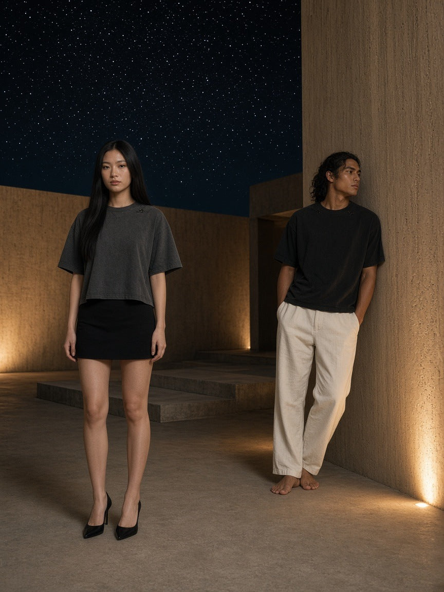 Marcel Afters Vintage Washed Distressed Boxy Oversized T-Shirt in Black, worn by a man and a woman, standing together on a night terrace, she in grey and he in black