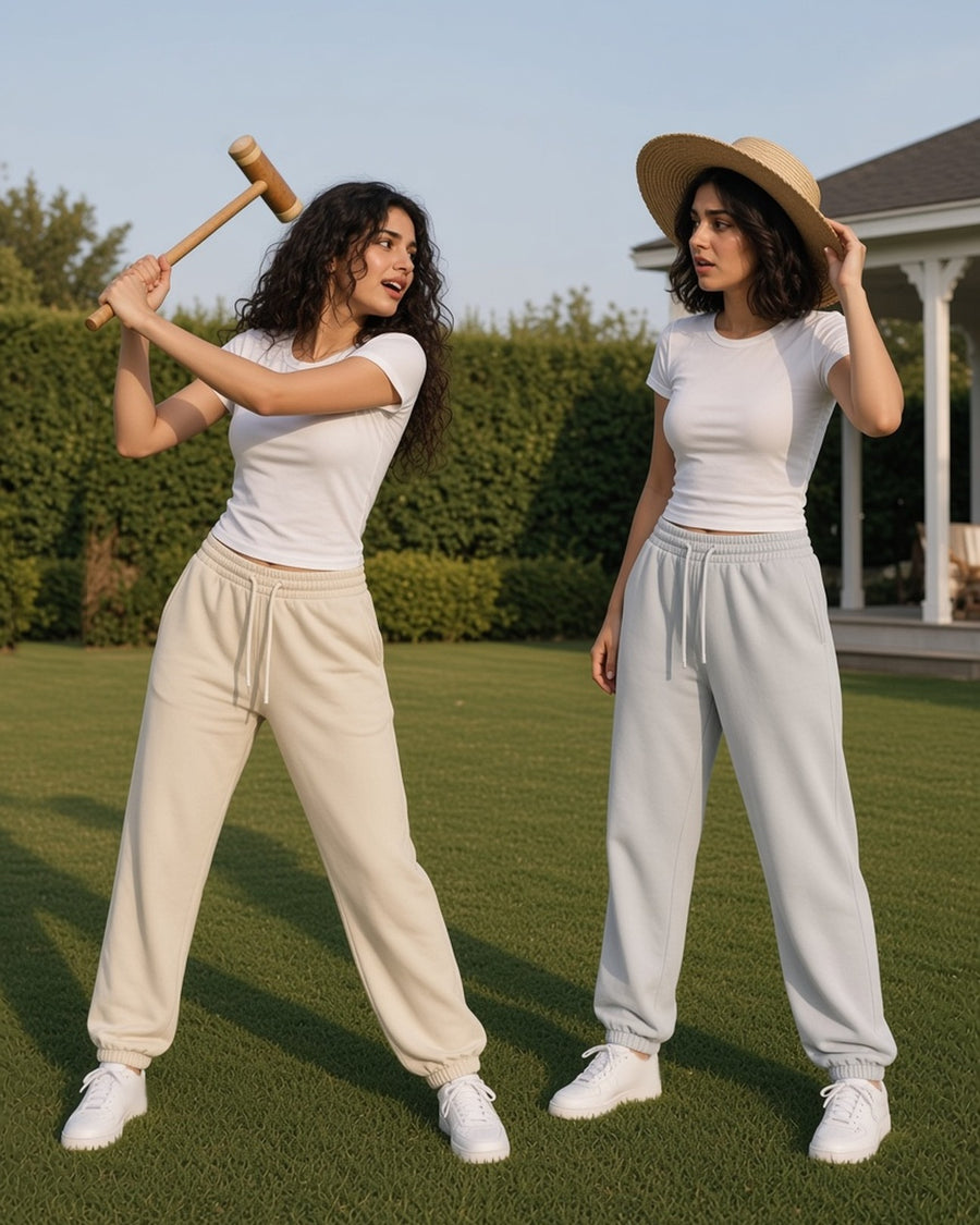 Two women in the Vintage Washed Fleece Jogger Sweatpants in Apricot and Light Gray playing croquet on a club lawn