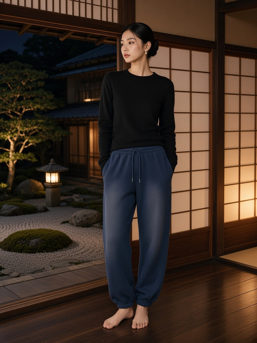 Marcel Afters Vintage Washed Fleece Jogger Sweatpants in Navy Blue, worn by a woman, standing in a Japanese courtyard house in a black top and navy joggers