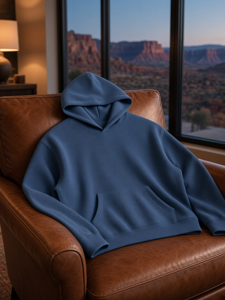 Marcel Afters Waffle Boxy Hoodie in Jeans Blue, laid flat, living room