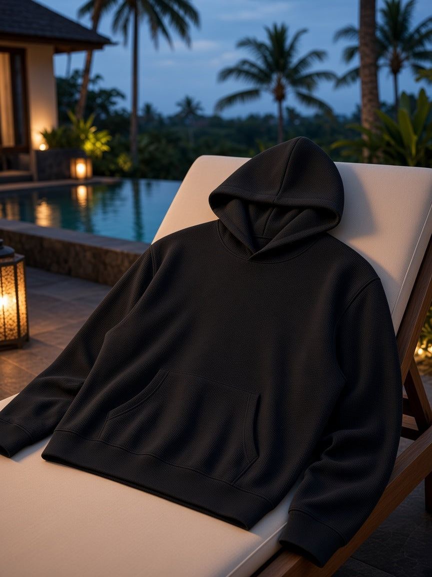 Marcel Afters Waffle Boxy Hoodie in Black, laid flat, poolside