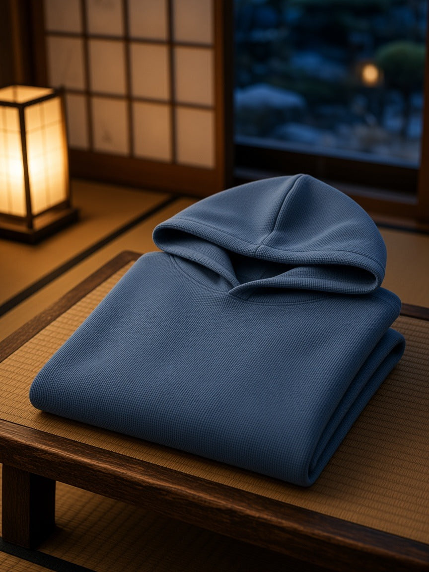 Marcel Afters Waffle Hoodie in Jeans Blue, laid flat, wooden table