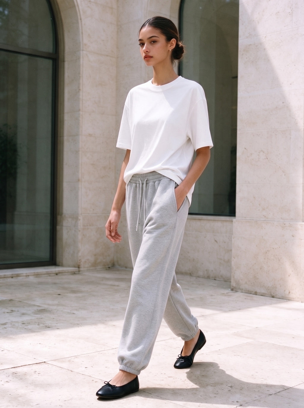 Woman wearing the Marcel Afters Women's Heavyweight Boxy T-Shirt, Light Tones in White, full-length editorial photograph