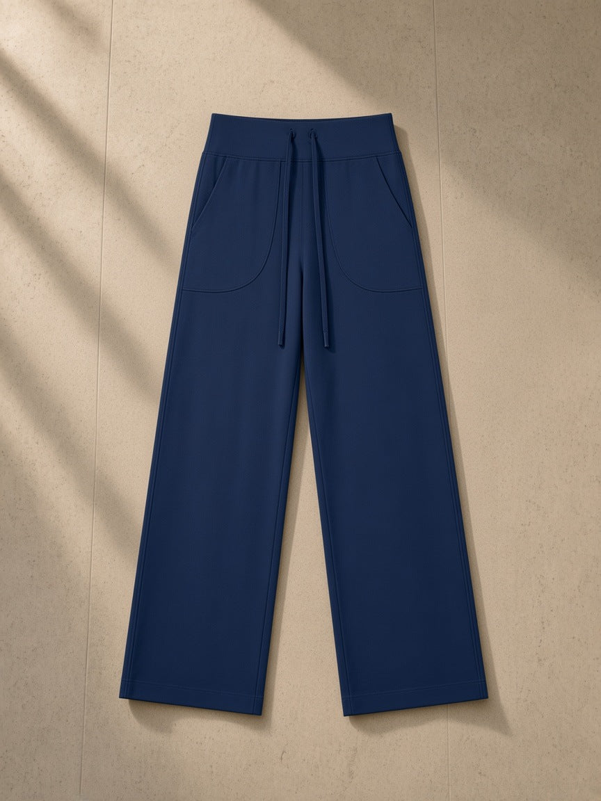 Women’s High Rise Straight Leg Yoga Pants in Navy Blue, laid flat on pale limestone