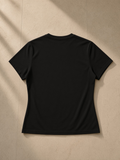 Women’s Slim Fit Performance T-Shirt in Black, laid flat on pale limestone, back view