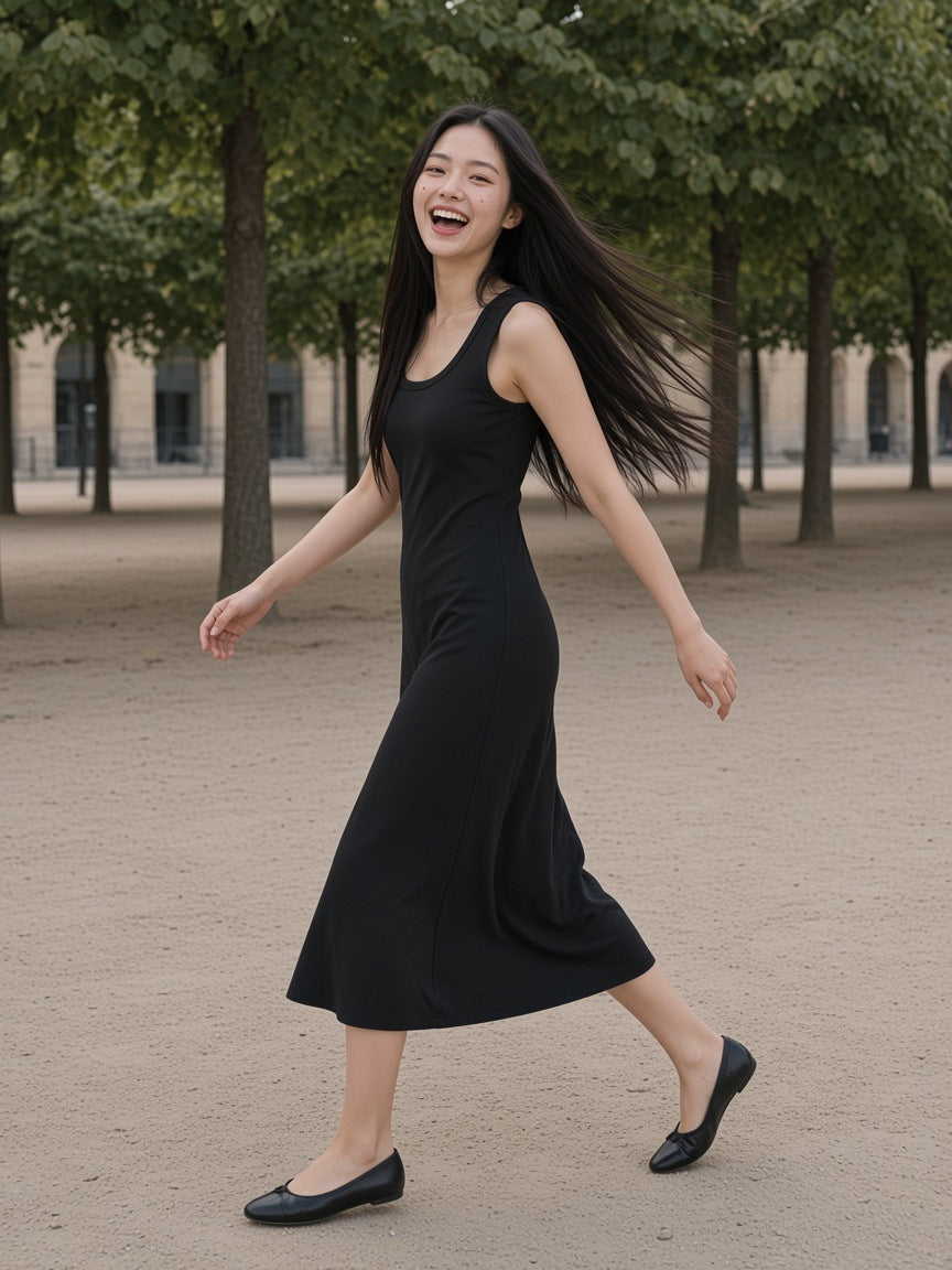 Woman in the Women's Slim Sleeveless Dress in Black turning on the gravel of the Palais-Royal garden in Paris in the morning