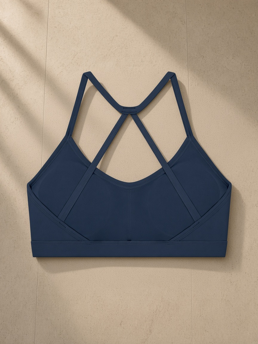 Women’s Tight Yoga Sports Bra in Navy Blue, laid flat on pale limestone, back view