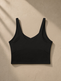 Women's V-Neck Yoga Sports Bra in Black, laid flat on pale limestone, back view
