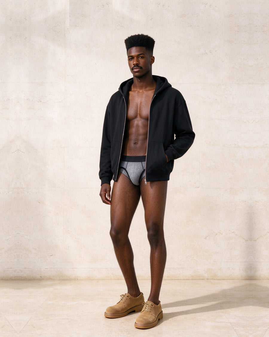 Marcel Afters Heavyweight Full Zip Hoodie in black, worn open with the True Notions Brief in Granite and Black and The Departure Derby