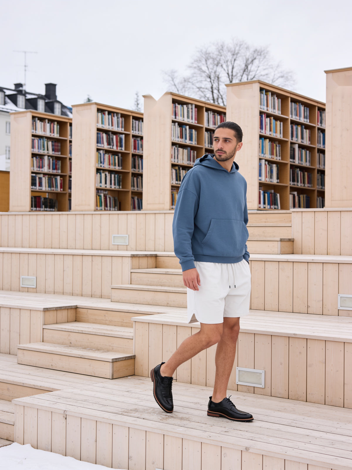 The Concierge Derby worn on model on pale wooden library steps in Oslo