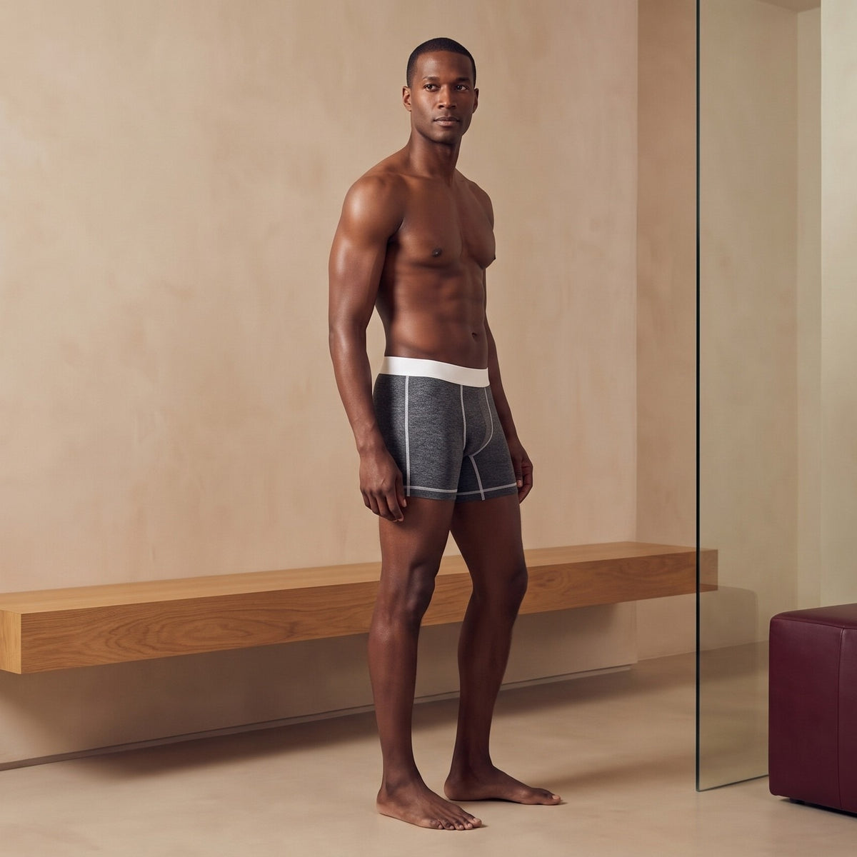 Man wearing the True Notions Boxer Brief — Granite / White, standing in a limestone studio, full-length photograph