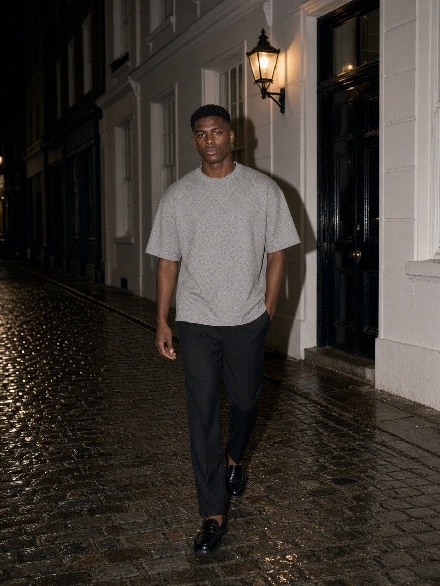 Man in the Marcel Afters Men's Heavyweight Boxy T-Shirt in Gray walking a Mayfair mews in London at night
