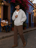 Man in a Flower Gray heavyweight full zip boxy hoodie on a colourful cobbled street at dusk