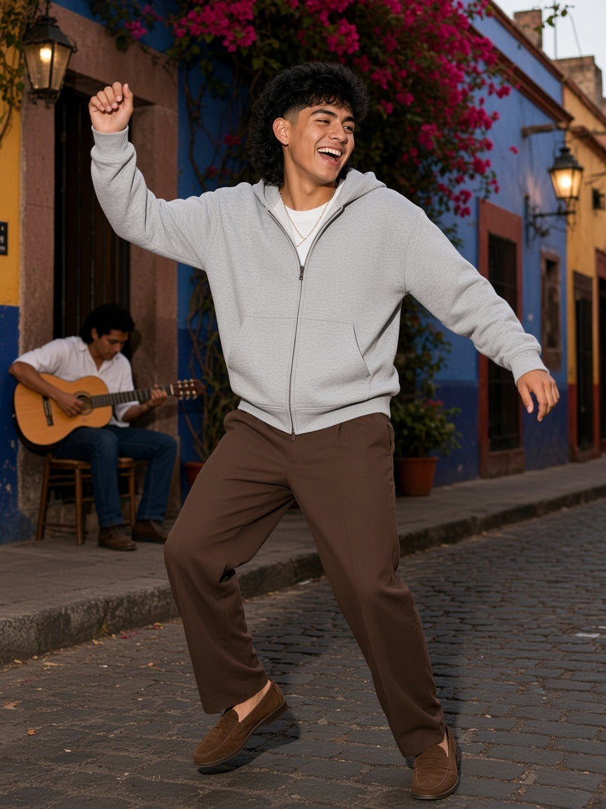 Man in the Marcel Afters Men's Heavyweight Full Zip Boxy Hoodie in Flower Gray worn open, against a pink plaster wall in Mexico City