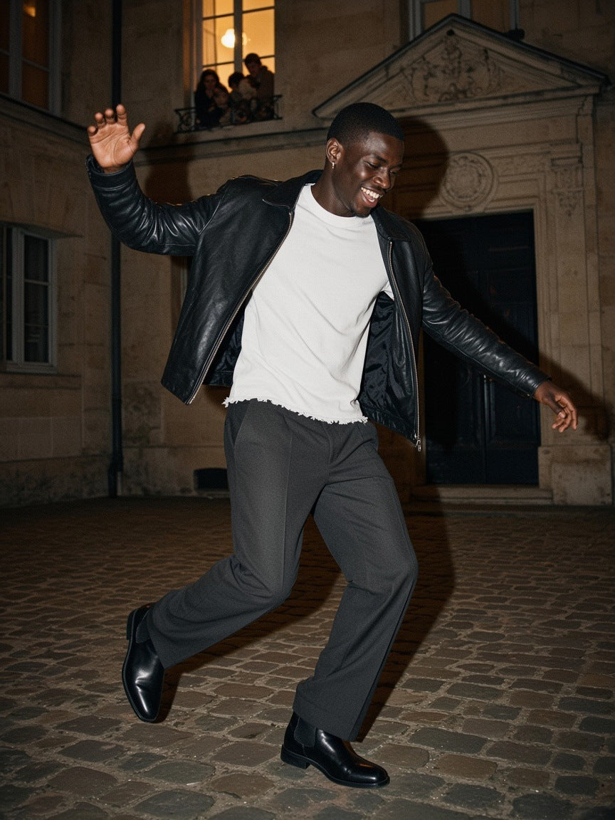 Man in the Men's Heavyweight Vintage Washed Frayed T-Shirt in White with a leather jacket, spinning in a Paris limestone courtyard at 1am