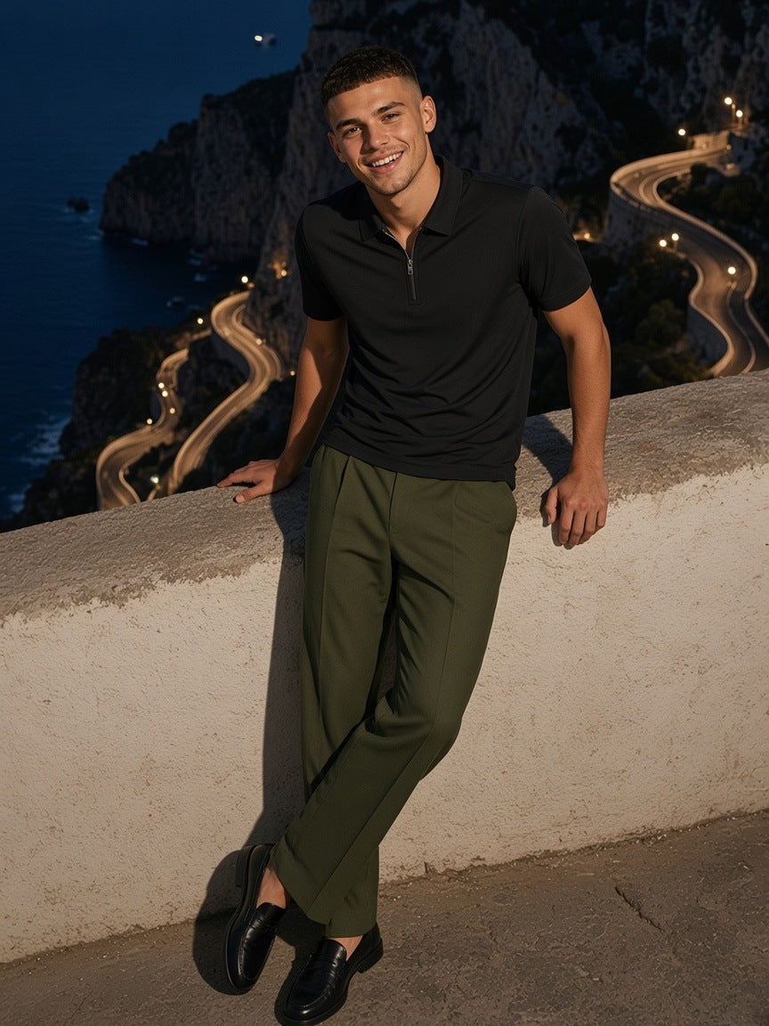 Man in the Men's Quarter-Zip Performance Polo Shirt in Black leaning on a stone wall above the Via Krupp on Capri at night