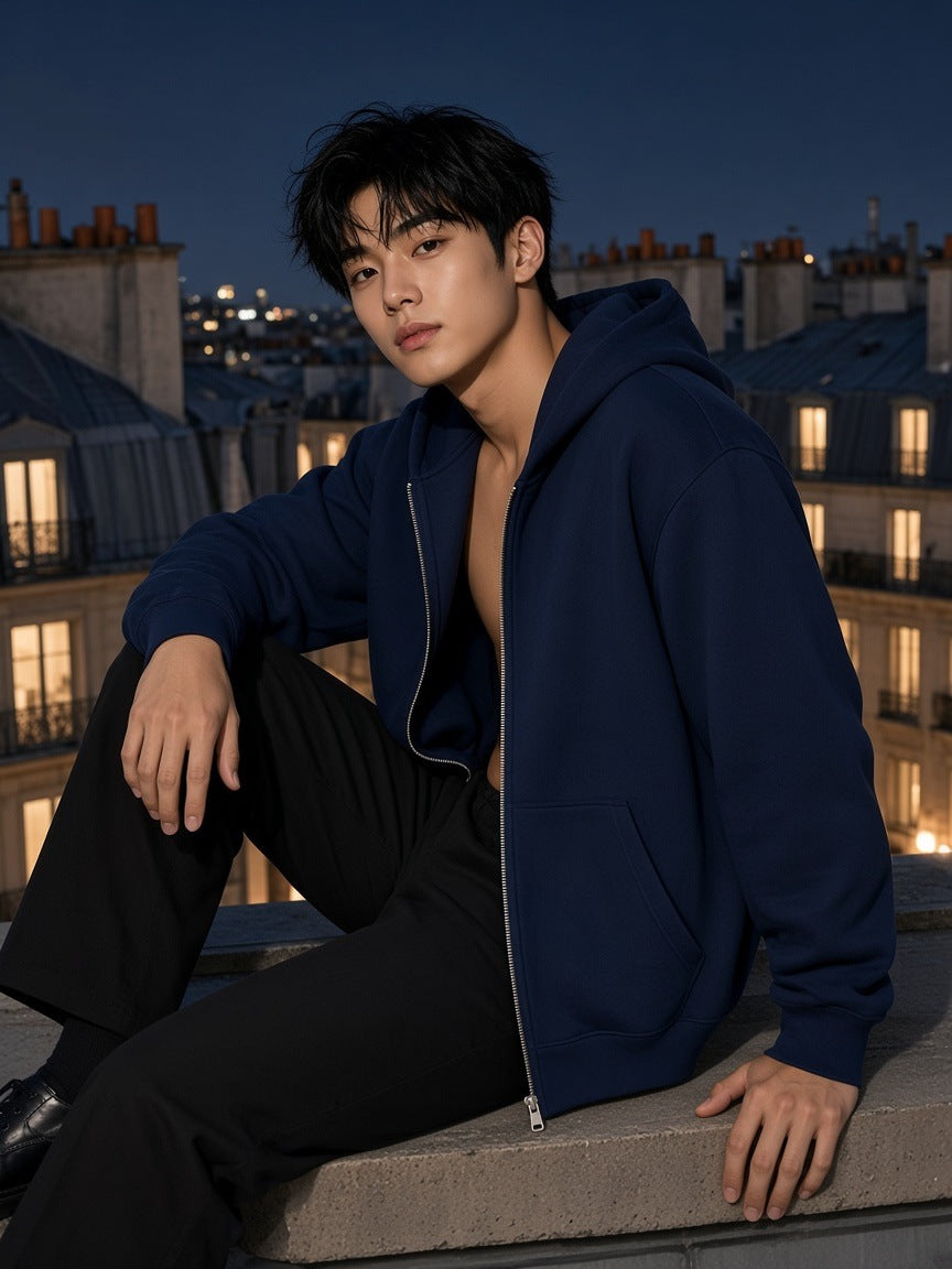 Man in the Men's Heavyweight Full Zip Hoodie in Navy Blue worn open on a Paris rooftop at night