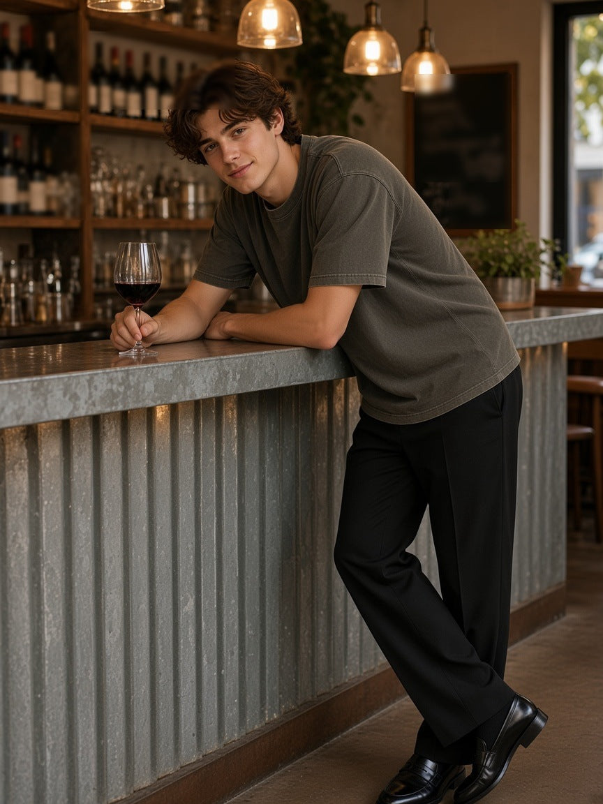 Man in the Men's Heavyweight Mineral Wash Boxy T-Shirt in Brown leaning on the zinc counter of a Paris wine bar