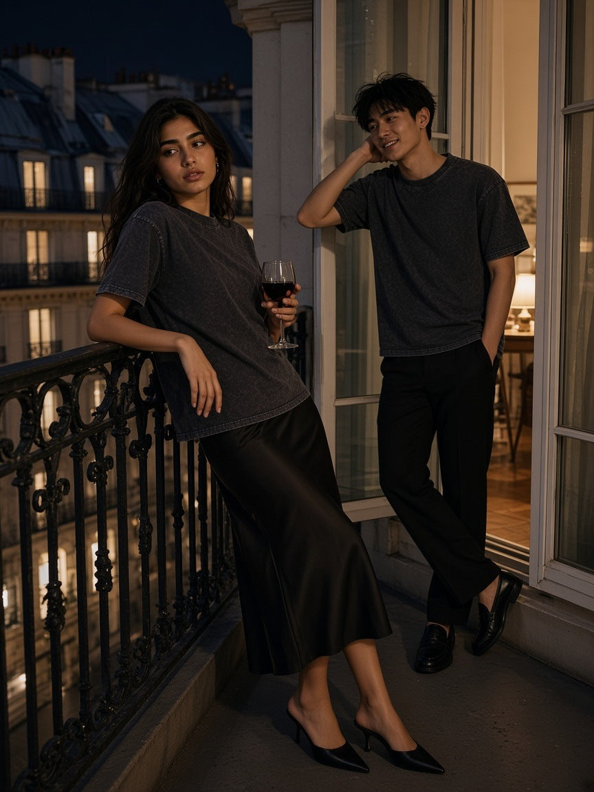 Woman and man in the Mineral Wash Boxy Cotton T-Shirt in Dark Gray and Black on a Haussmann balcony in Paris at night