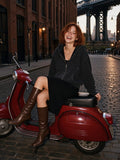 Woman in the Mineral Wash Boxy Full Zip Hoodie in Dark Gray over a black slip dress, laughing on a red Vespa in DUMBO, Brooklyn at dusk