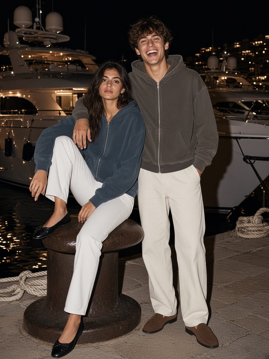Two people in the Marcel Afters Mineral Wash Boxy Full Zip Hoodie in Coffee and Navy Blue on the Monaco harbour quay at night