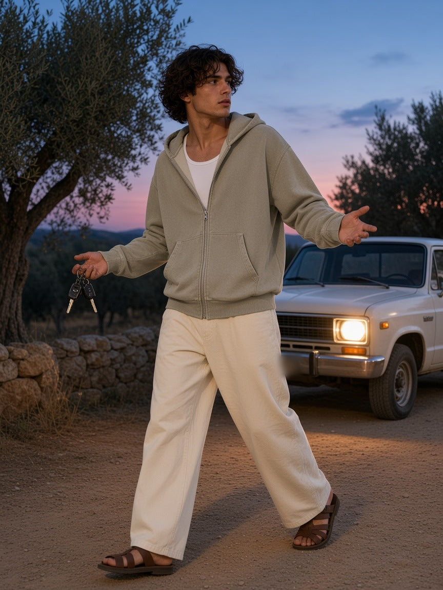 Man in the Mineral Wash Boxy Full Zip Hoodie in Khaki in a roadside olive grove by a pickup truck at blue hour