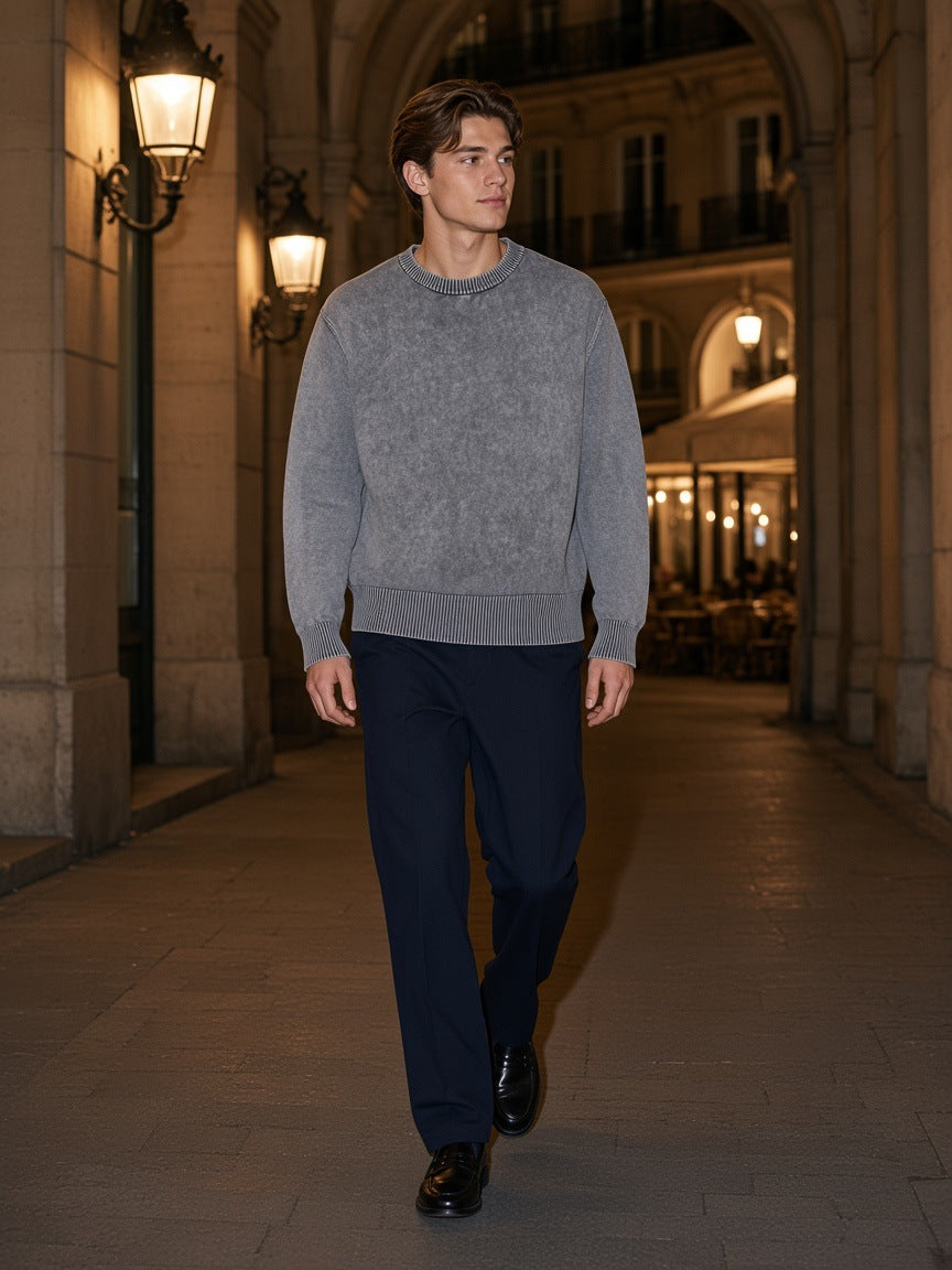 Man in the Mineral Wash Oversized Sweater in Gray walking through a lantern-lit Paris arcade at night
