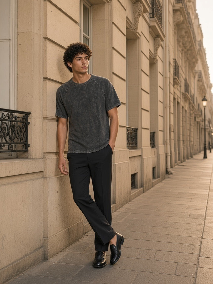 Man in the Mineral Wash Raw Edge T-Shirt in Black leaning against a Haussmann facade in Paris in the morning