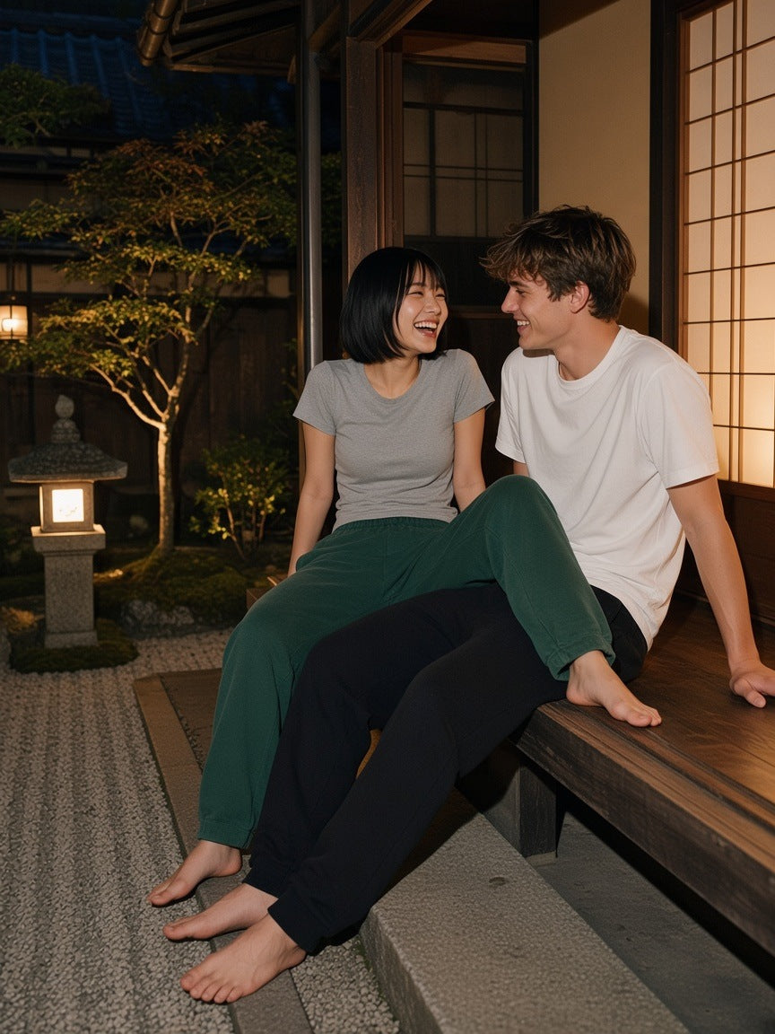 Two people in the Mineral Wash Straight Sweatpants in Black and Blackish Green in a Kyoto garden at night