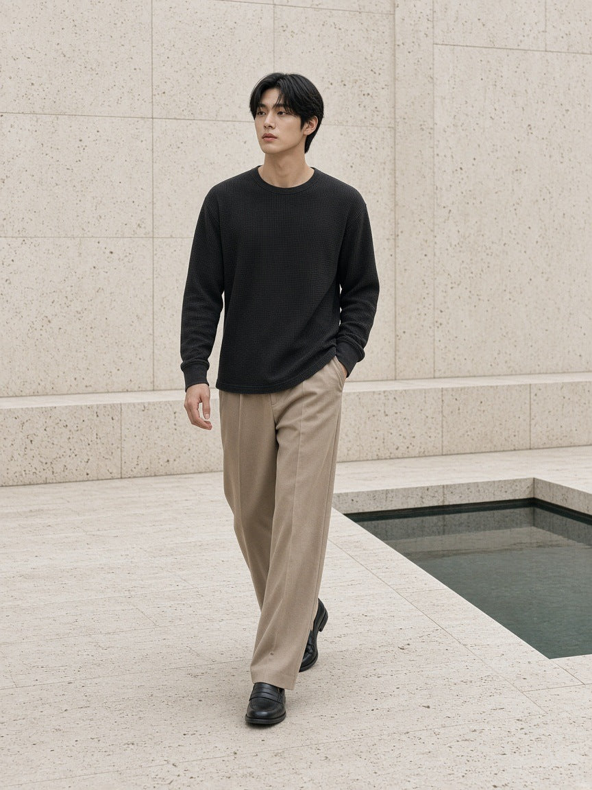 Man in the Mineral Wash Waffle Oversized T-Shirt in Black, walking through a travertine courtyard in Seoul