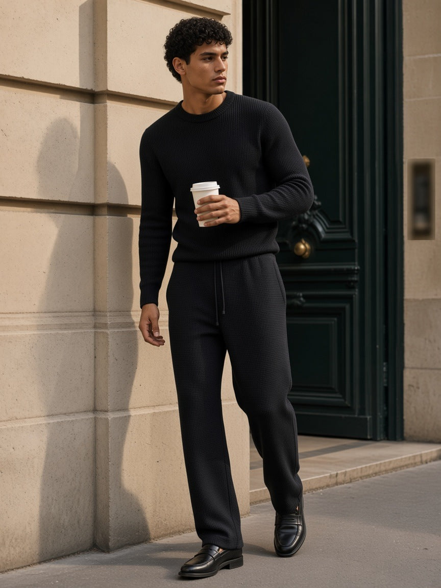 Man in the Mineral Wash Waffle Sweatpants in Black, beside a Haussmann doorway in Paris in the morning