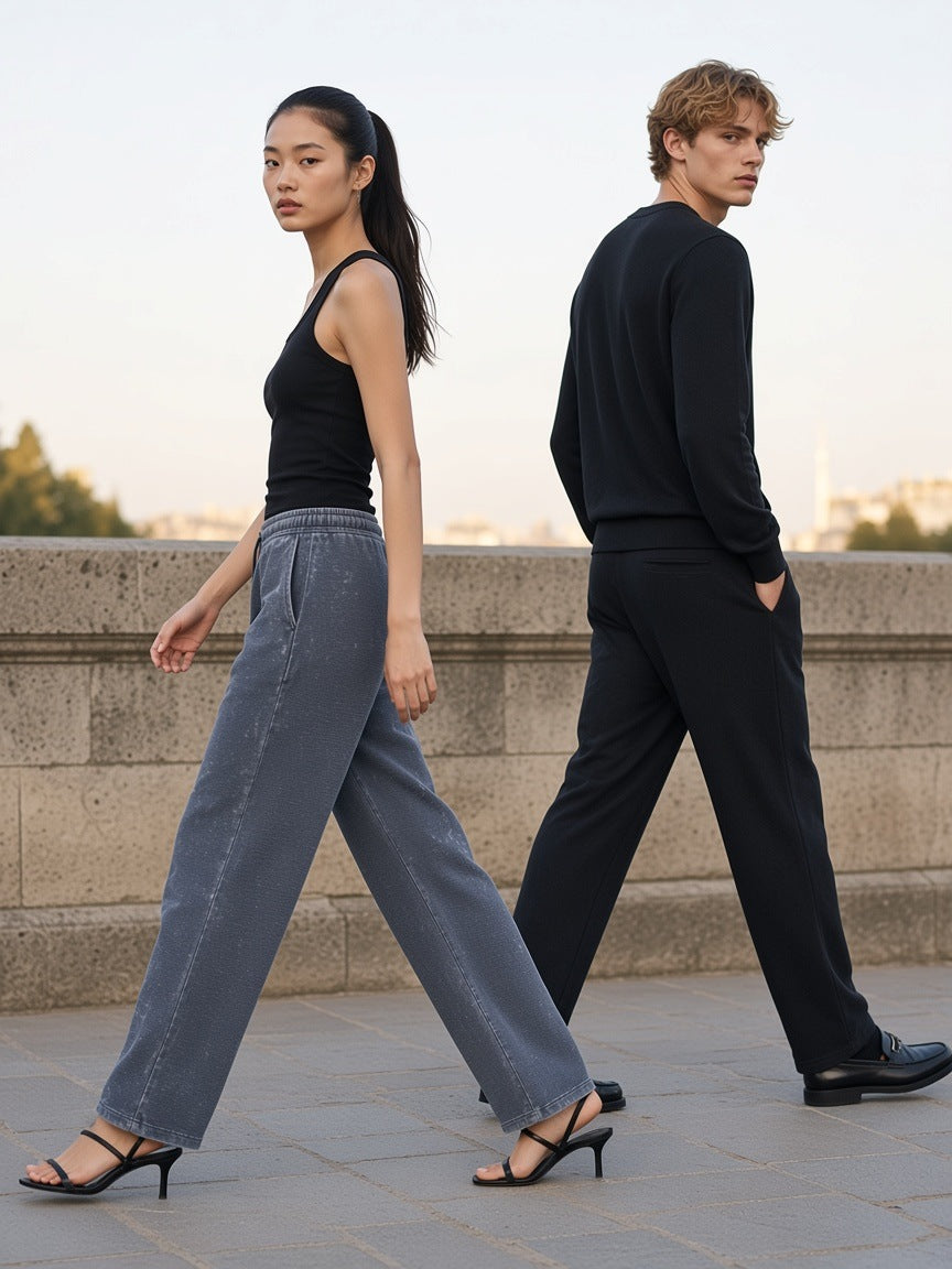 Two people in the Marcel Afters Mineral Wash Waffle Sweatpants in Gray Blue and Black on an empty Paris quai at dawn