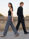Two people in the Mineral Wash Waffle Sweatpants in Gray Blue and Black on an empty Paris quai at dawn