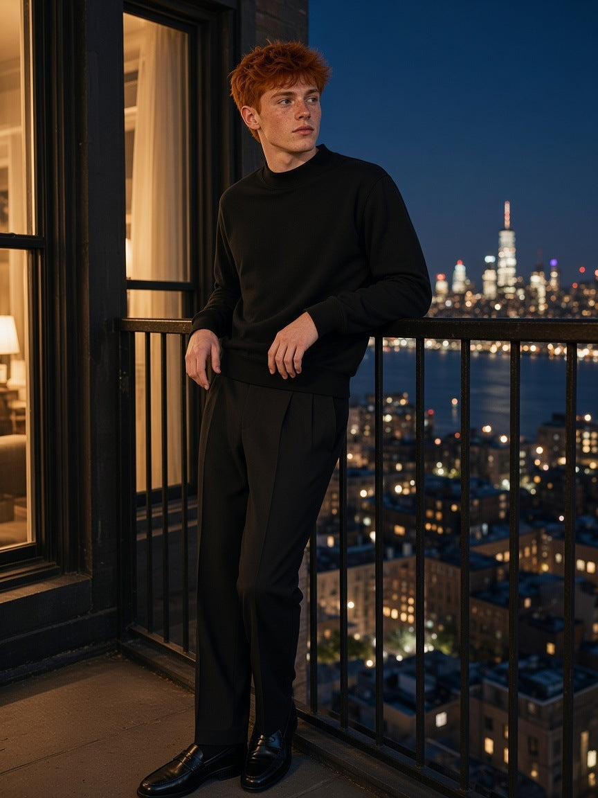 Man in the Mock Neck Sweatshirt in Black, on a loft balcony over the Hudson in Tribeca, New York at night