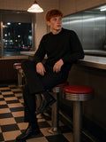 Man in the Mock Neck Sweatshirt in Black, on a counter stool in a Bowery diner in New York at night