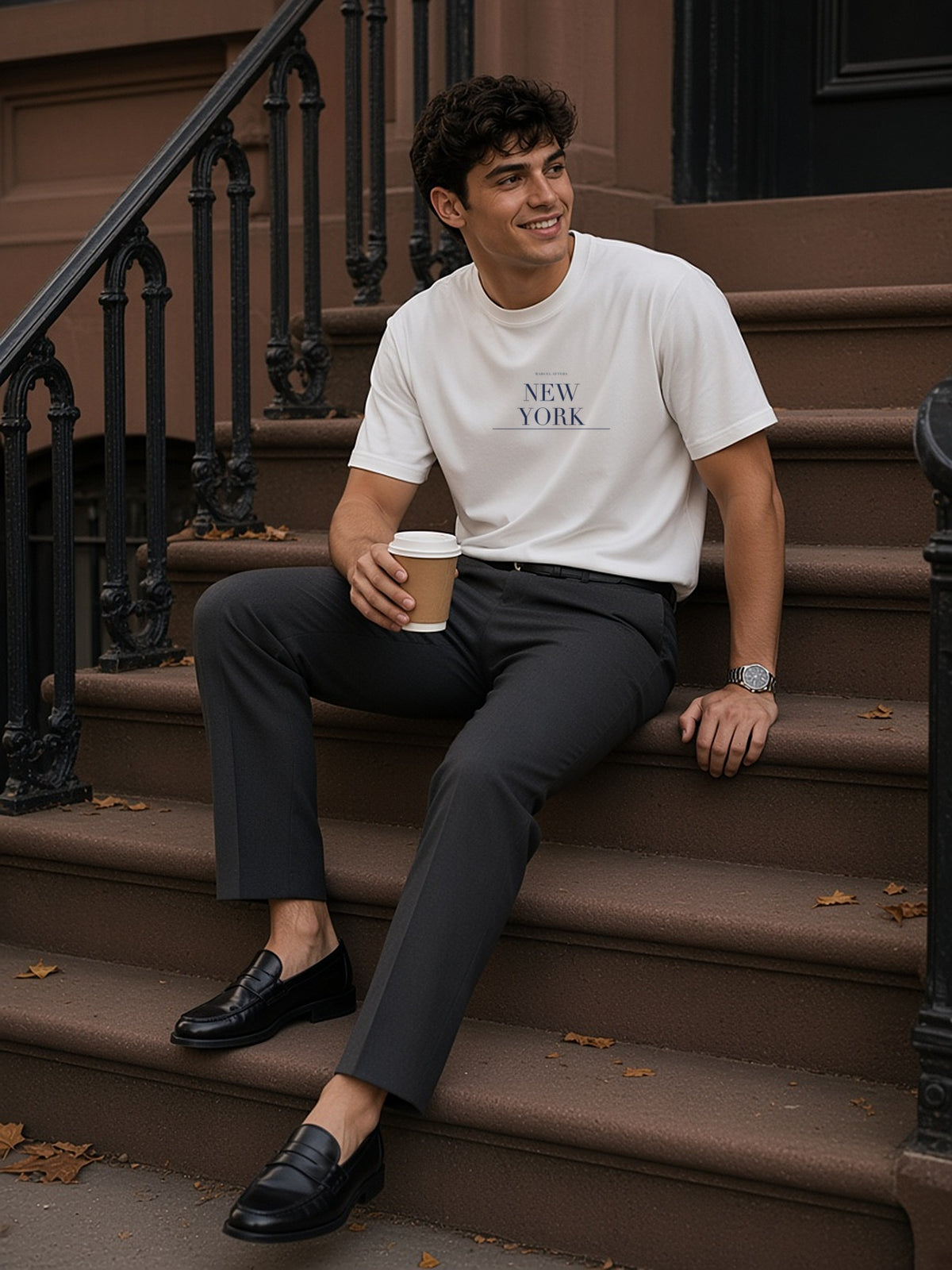 Man in the New York tee in White seated on a West Village brownstone stoop with a morning coffee
