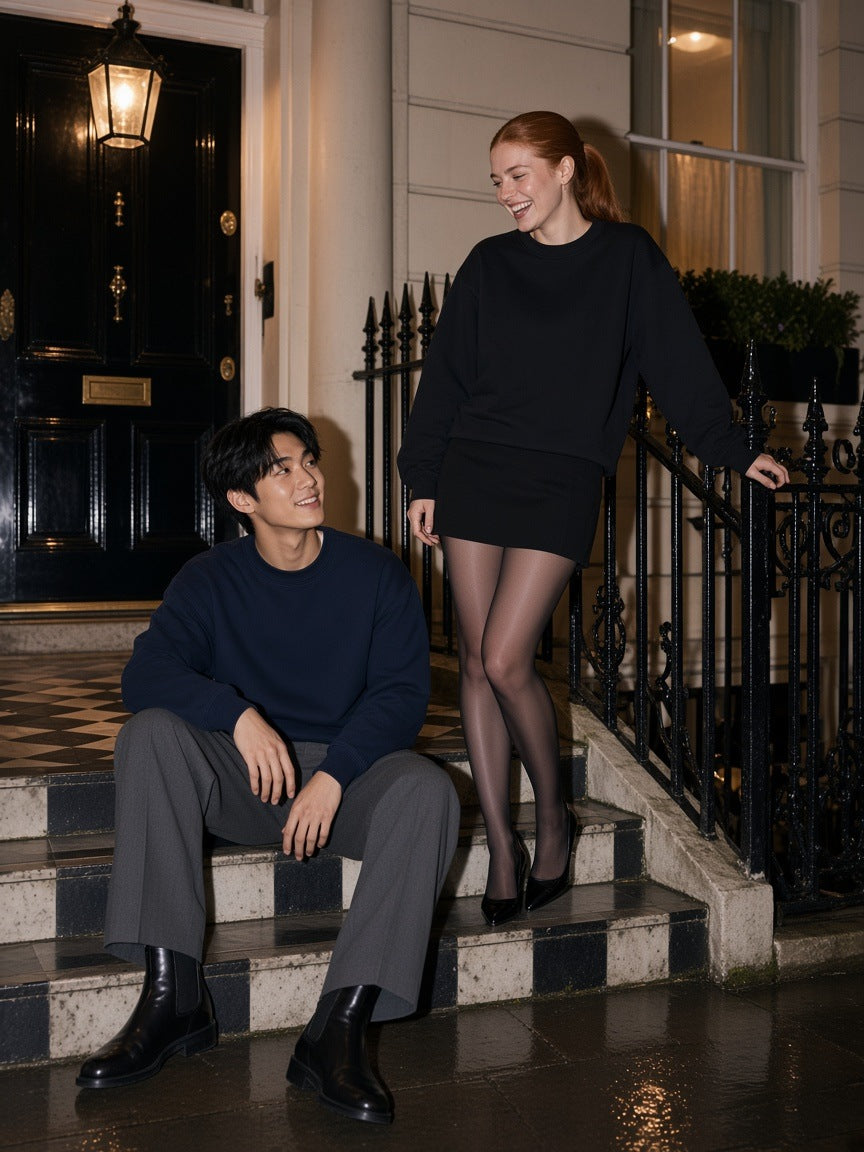 Two people in the Marcel Afters Oversized Drop Shoulder Crewneck Sweatshirt in Navy Blue and Black on London townhouse steps at night
