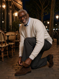 Man in the Oversized Drop Shoulder Crewneck Sweatshirt in Oat Gray tying a shoe by a café terrace in Paris at night