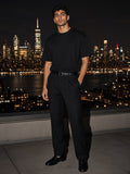 Man in the Marcel Afters Oversized Drop Shoulder T-Shirt in Black on a rooftop over the Hudson in New York at night